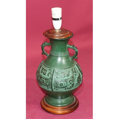 7207 - A green bronzed round bulbous thin necked 2-handled table lamp, on platform base, with raised Viking... 