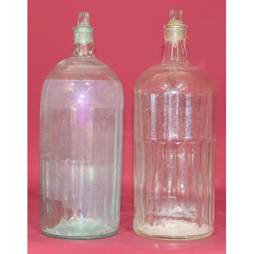 7211 - A clear glass Poison bottle with stopper, 34.5cm high and another similar bottle (2)