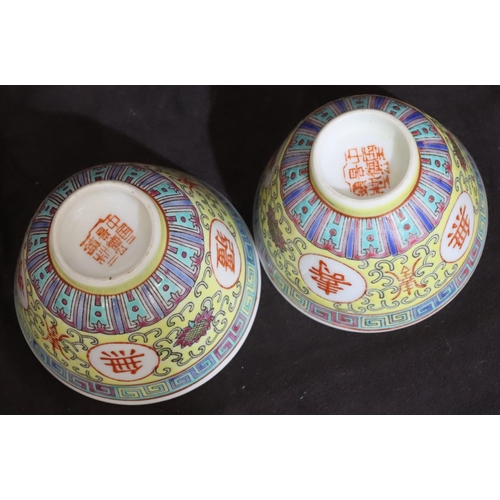 132 - A pair of Oriental tea bowls on yellow ground with coloured key pattern, scroll and floral decoratio... 