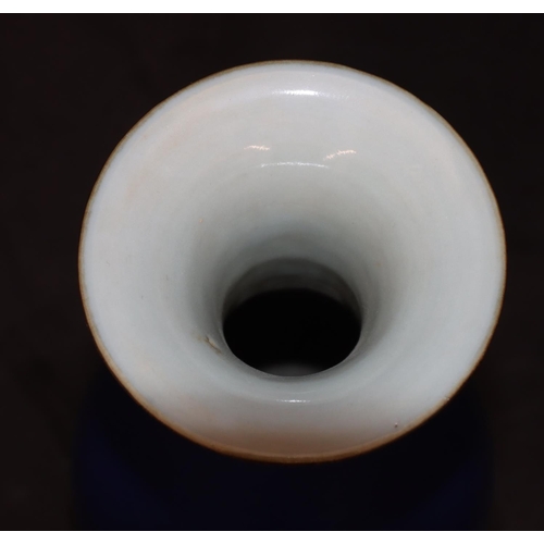 134 - An Oriental round bulbous thin necked trumpet shaped vase on blue ground, 22.5cm high