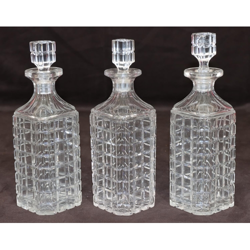 27 - A set of 3 cut glass square decanters with thumb pattern necks and stoppers, 23cm high