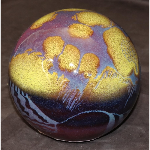 33 - A glazed earthenware globe with yellow and purple decoration, 19cm high