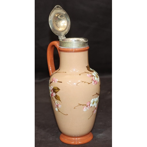 34 - A Victorian glazed earthenware round bulbous jug with silver plated neck and hinged lid on brown gro... 