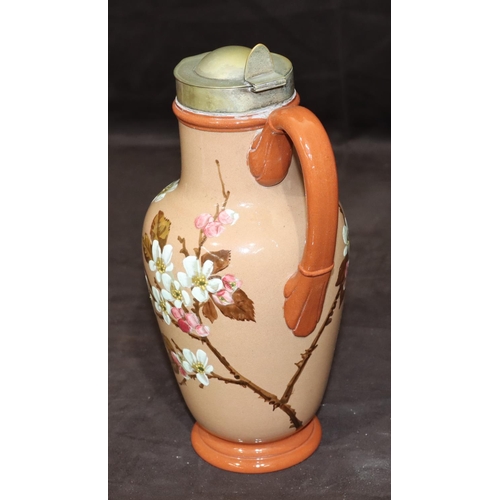 34 - A Victorian glazed earthenware round bulbous jug with silver plated neck and hinged lid on brown gro... 