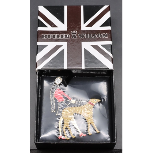 386 - Butler & Wilson brooch in the form of a lady walking a dog (Boxed and unopened)