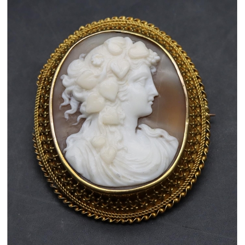 395 - A 19th Century oval gold frame cameo with raised figurehead of a lady with hearts plaited in her hai... 