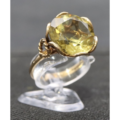 403 - A 9ct gold ladies' ring set with yellow stone with circular shaped shoulders, size O, 4.3 grams gros... 