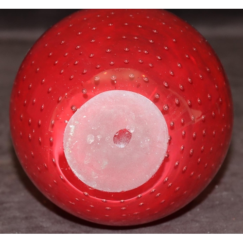 42 - A heavy red glass round bulbous thin necked vase with inner ball decoration, 25cm high