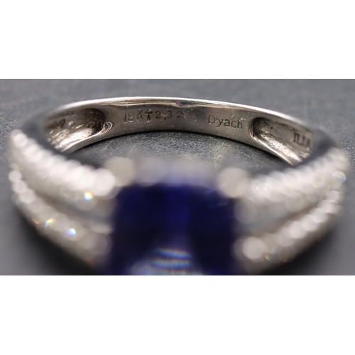 443 - An 18ct white gold ladies' dress ring set with centre tanzanite flanked by diamonds to open shoulder... 