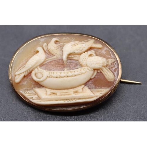 447 - A 9ct gold oval cameo brooch with raised urn and bird motifs, 3cm wide, 3.8 grams gross