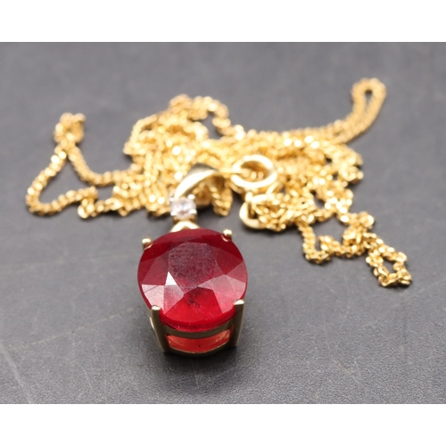 452 - A 10ct gold pendant set with ruby mounted with small diamond, with chain, overall weight 5.2 grams g... 