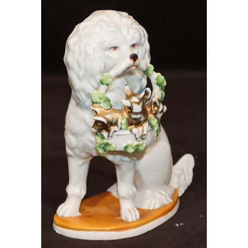 46 - A Bisque Staffordshire style figure of a seated spaniel holding basket in its mouth, 19cm high