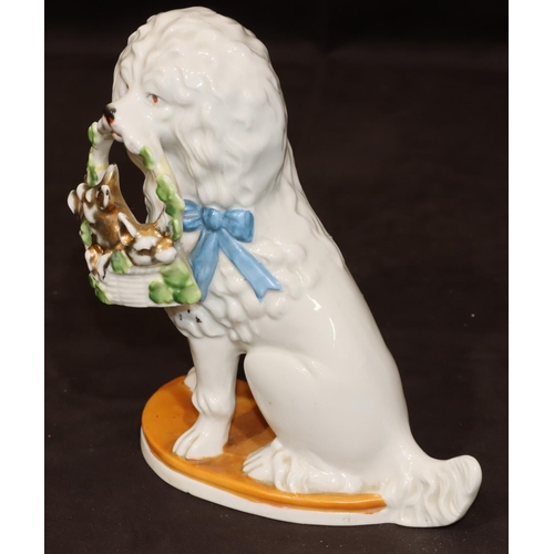 46 - A Bisque Staffordshire style figure of a seated spaniel holding basket in its mouth, 19cm high