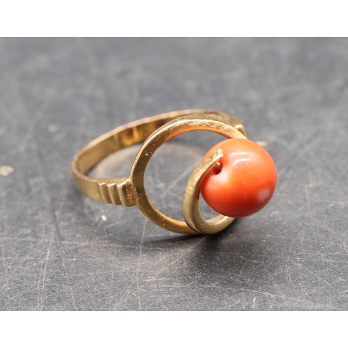 489 - A Continental gold ladies' ring set with coral, with open shoulders, size O/P, 3.5 grams gross