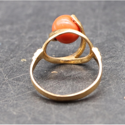 489 - A Continental gold ladies' ring set with coral, with open shoulders, size O/P, 3.5 grams gross