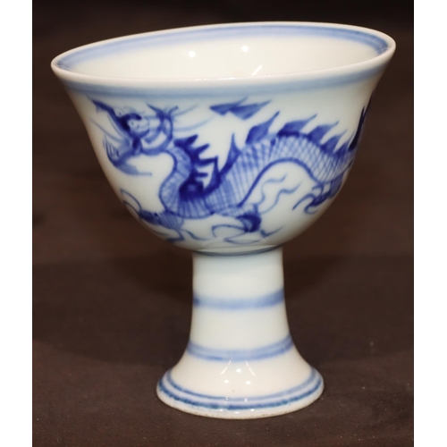 49 - A blue and white Oriental round trumpet shaped cup on sweeping foot with dragon motif