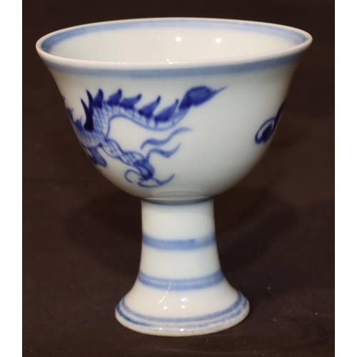 49 - A blue and white Oriental round trumpet shaped cup on sweeping foot with dragon motif