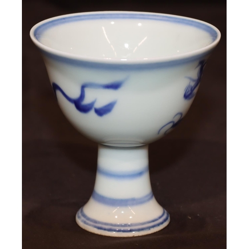 49 - A blue and white Oriental round trumpet shaped cup on sweeping foot with dragon motif