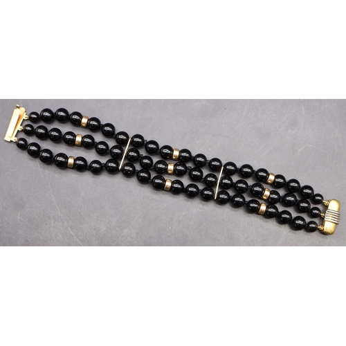 497 - A 14ct gold and triple row black bead bracelet, mounted with further gold beads, 19cm long