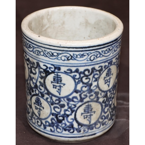 50 - An Oriental cylindrical blue and white brush pot with allover inscription and scroll decoration, 11.... 