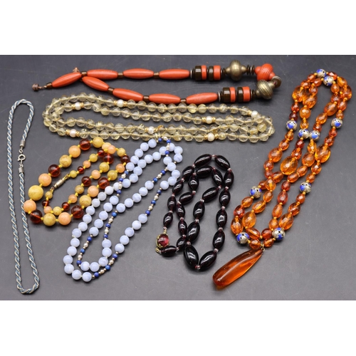 501 - An amber bead necklace with chamfer decoration interspersed with small silver and blue enamelled bal... 