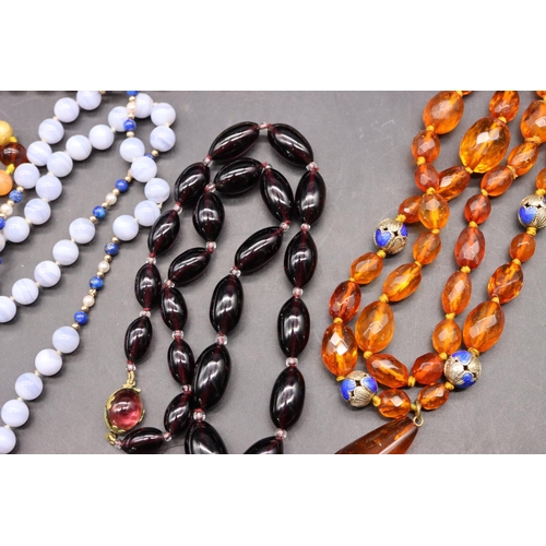 501 - An amber bead necklace with chamfer decoration interspersed with small silver and blue enamelled bal... 