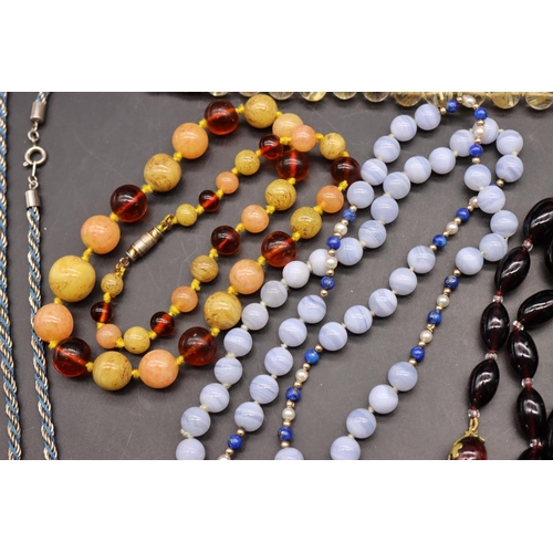 501 - An amber bead necklace with chamfer decoration interspersed with small silver and blue enamelled bal... 