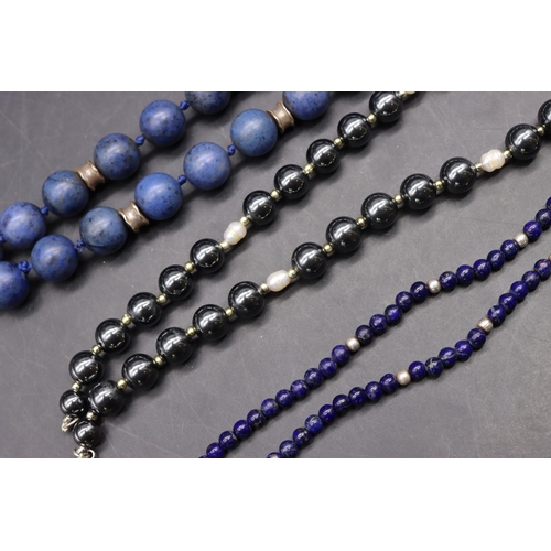 503 - A blue bead and silver necklace, a metal bead and silver necklace and a small lapis lazuli and silve... 