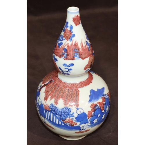 51 - An Oriental round gourd shaped vase on white, red and blue ground with figure decoration, 22.5cm hig... 