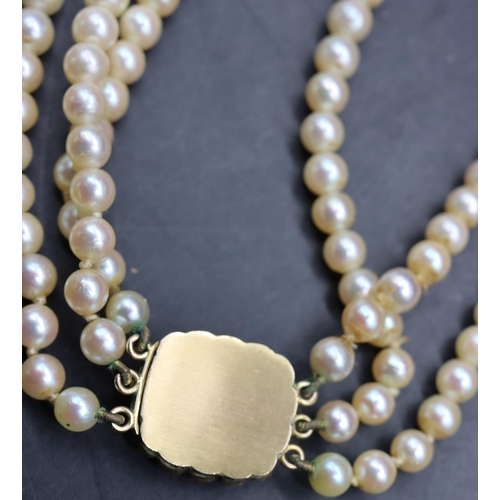 511 - A cultured pearl triple row choker necklace with gold clasp inset with Citrine style stone and half ... 