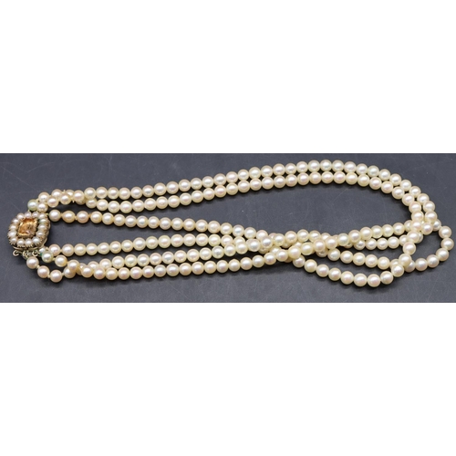 511 - A cultured pearl triple row choker necklace with gold clasp inset with Citrine style stone and half ... 