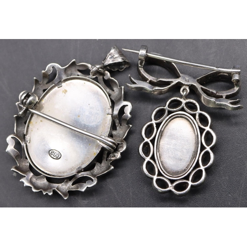 521 - A silver and cut steel drop locket set with a miniature of a lady with ribbon motif to top, another ... 