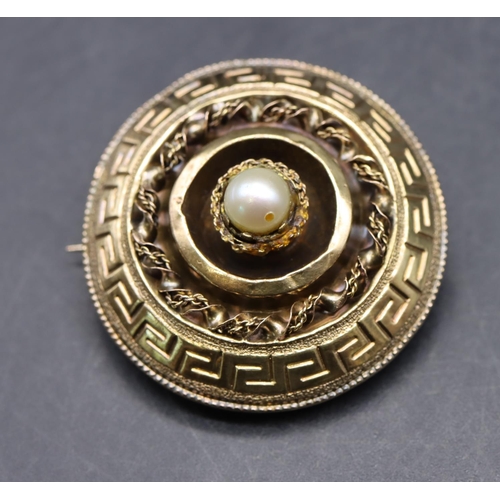 534 - A gold circular brooch with centre pearl motif (glass back cracked), 3.2cm diameter, 6.8 grams gross