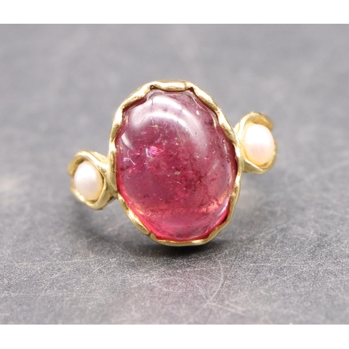 550 - An 18ct gold ladies' ring set with red cabochon flanked by 2 half pearls, size R, 5.3 grams gross