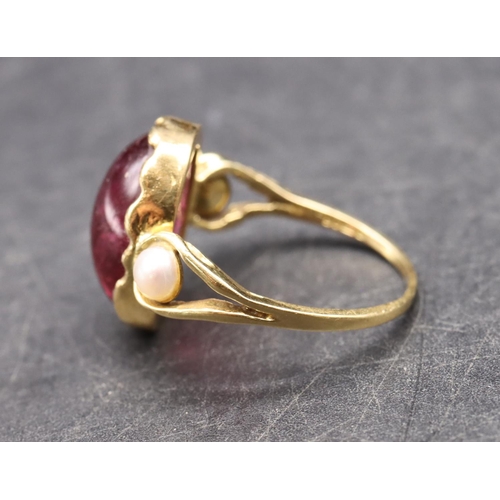 550 - An 18ct gold ladies' ring set with red cabochon flanked by 2 half pearls, size R, 5.3 grams gross