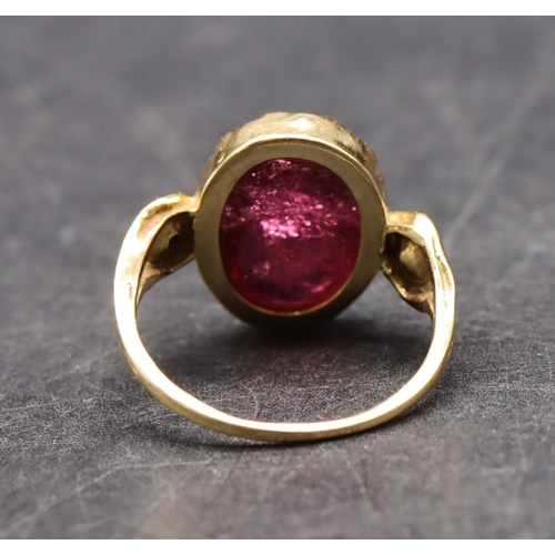 550 - An 18ct gold ladies' ring set with red cabochon flanked by 2 half pearls, size R, 5.3 grams gross