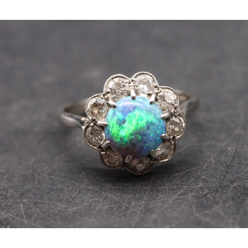 552 - A platinum ladies' cluster ring set with centre black opal surrounded by 9 diamonds (each approx. 0.... 