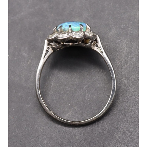 552 - A platinum ladies' cluster ring set with centre black opal surrounded by 9 diamonds (each approx. 0.... 