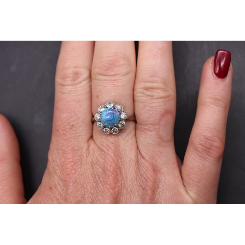 552 - A platinum ladies' cluster ring set with centre black opal surrounded by 9 diamonds (each approx. 0.... 