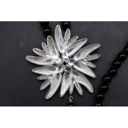 553 - A Lalique 925 silver drop pendant mounted with frosted glass figures of birds, on black bead necklac... 