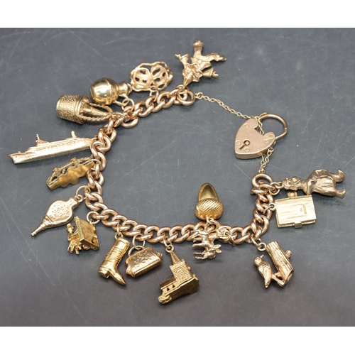 560 - A 9ct gold bracelet with padlock clasp mounted with 16 gold charms, 58 grams