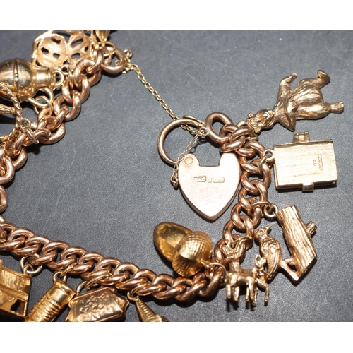 560 - A 9ct gold bracelet with padlock clasp mounted with 16 gold charms, 58 grams