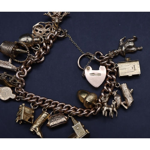 560 - A 9ct gold bracelet with padlock clasp mounted with 16 gold charms, 58 grams