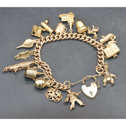 560 - A 9ct gold bracelet with padlock clasp mounted with 16 gold charms, 58 grams