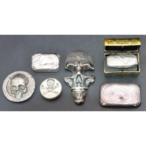 571 - A silver paperweight in the form of a scull, another silver scull and 4 silver nuggets. (6)