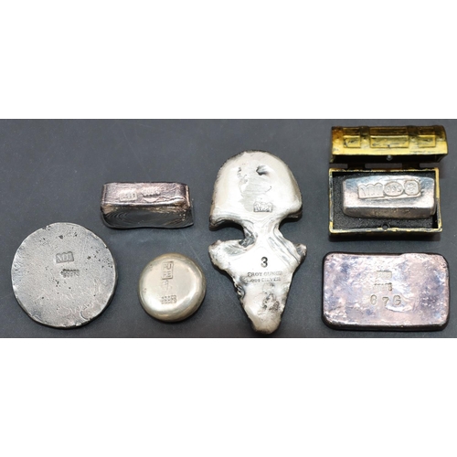 571 - A silver paperweight in the form of a scull, another silver scull and 4 silver nuggets. (6)