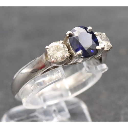 579 - An 18ct white gold ladies 3-stone ring set with centre sapphire flanked by 2 diamonds (diamonds appr... 