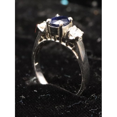 579 - An 18ct white gold ladies 3-stone ring set with centre sapphire flanked by 2 diamonds (diamonds appr... 