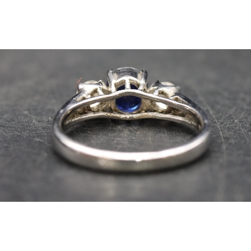 579 - An 18ct white gold ladies 3-stone ring set with centre sapphire flanked by 2 diamonds (diamonds appr... 