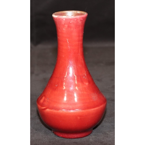 69 - A Liberty small Flambé round bulbous thin necked vase on red ground, 14.5cm high